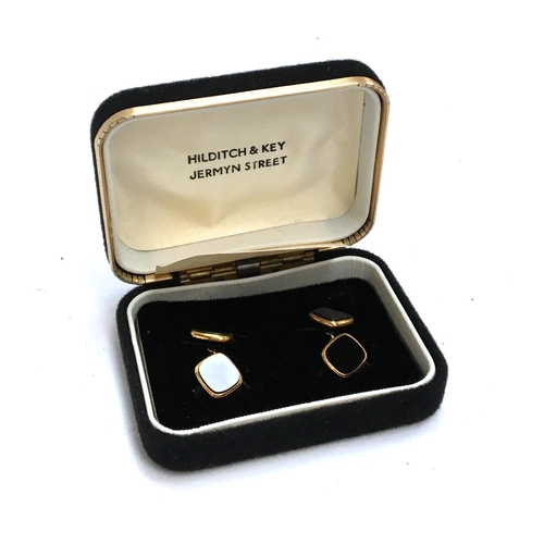 642 - A pair of Hilditch & Key black onyx and yellow metal cufflinks in presentation box