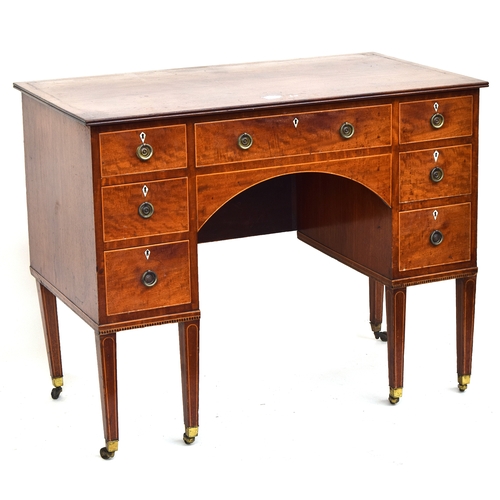 555 - A Regency mahogany kneehole dressing table, with an arrangement of seven drawers, with light wood st... 