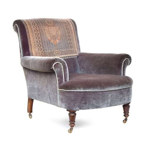 623 - A 19th century armchair, woven carpet panel, with outswept arms on turned casters