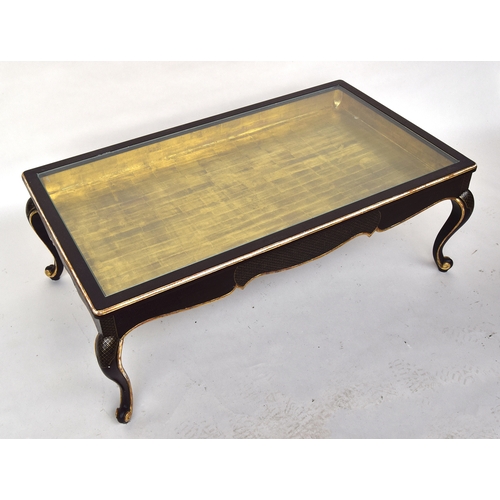 647 - A 20th century ebonised and parcel gilt coffee table, glass inset top with gilt interior, raised on ... 