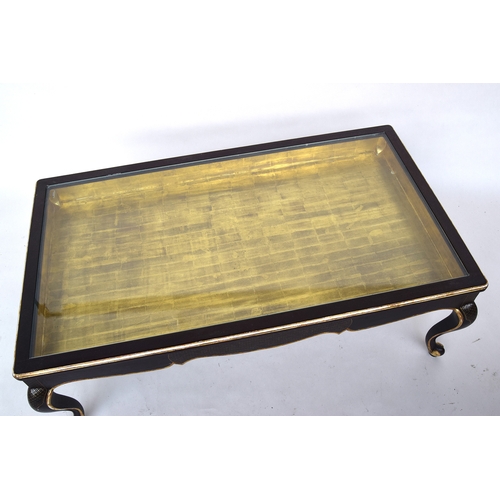 647 - A 20th century ebonised and parcel gilt coffee table, glass inset top with gilt interior, raised on ... 