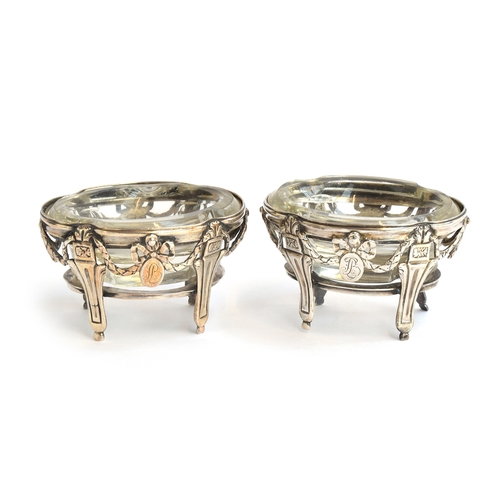 70 - A pair of white metal Neo-classical salts, each with heavy glass liner, chased with bows and swags, ... 