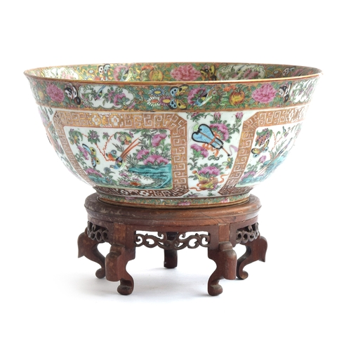 182 - A large 19th century Chinese famille rose punch bowl, depicting four panels of flora and fauna surro... 