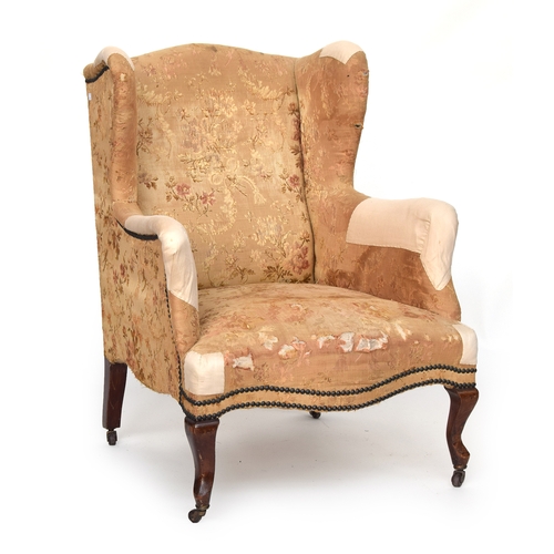 625 - A Regency wingback armchair with serpentine front, raised on brass casters