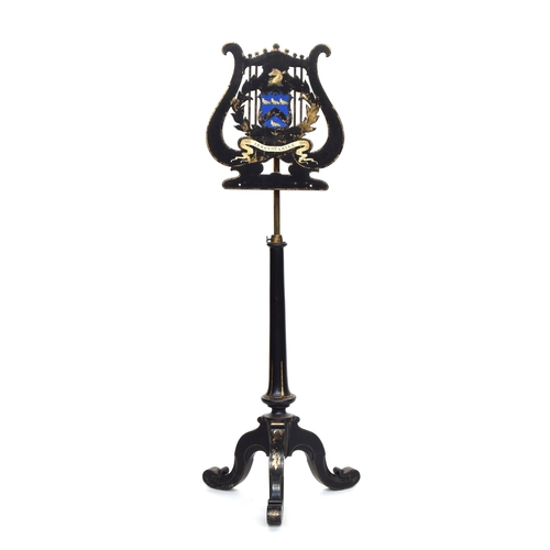 593 - A Victorian ebonised music stand by Jennens & Bettridge, the lyre form top with armorial crest depic... 