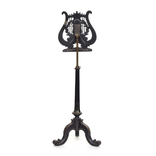 593 - A Victorian ebonised music stand by Jennens & Bettridge, the lyre form top with armorial crest depic... 