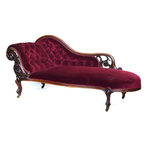 628 - A Victorian chaise longue, button upholstered, on a carved mahogany frame