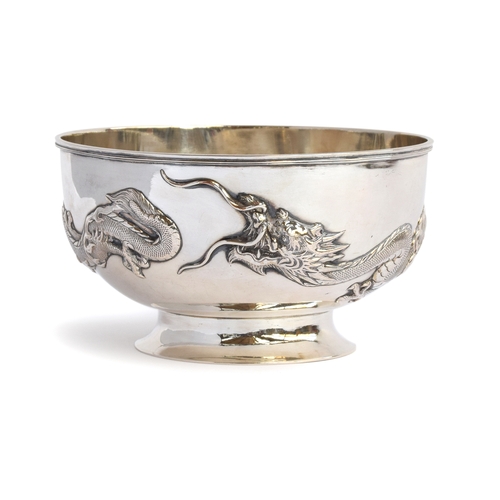 89 - A Chinese silver rose bowl, encircled by two chased dragons in relief, on a circular spreading foot,... 