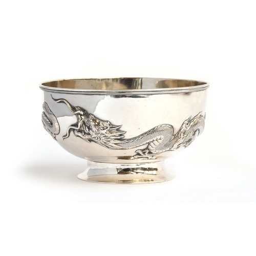 89 - A Chinese silver rose bowl, encircled by two chased dragons in relief, on a circular spreading foot,... 