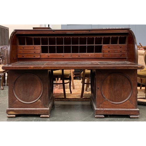 557A - A substantial Anglo-Indian rolltop desk, containing numerous fitted pigeonholes and drawers, over a ... 