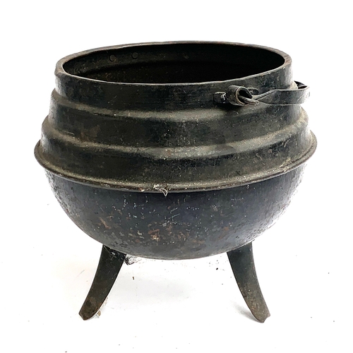 154 - A cast iron three legged cauldron, containing a quantity of corks