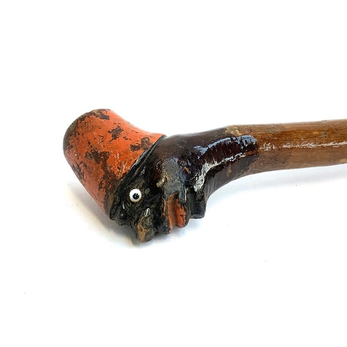 195 - A walking cane with carved handle in the form of a blackamoor wearing a red hat, glass eye detail, 7... 