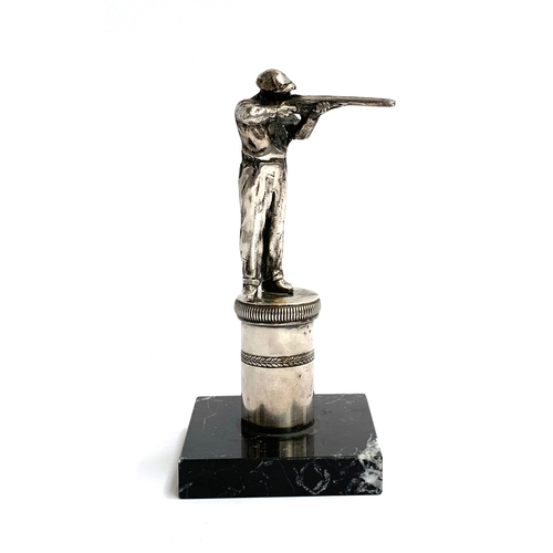 64 - A silver plated shotgun shooting trophy, modelled as a marksman on a plinth with laurel frieze, on m... 