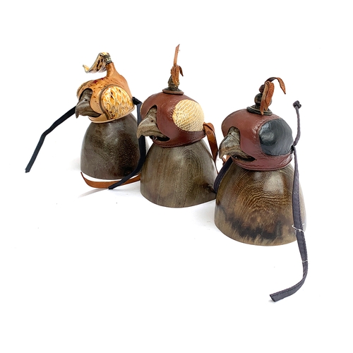 19 - Three falconry hoods, on carved wooden stands (3)