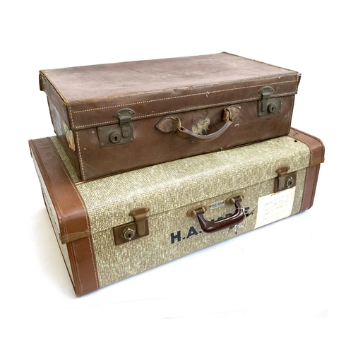 1051 - A vintage leather suitcase, the top monogrammed H.M; together with one other canvas and leather suit... 