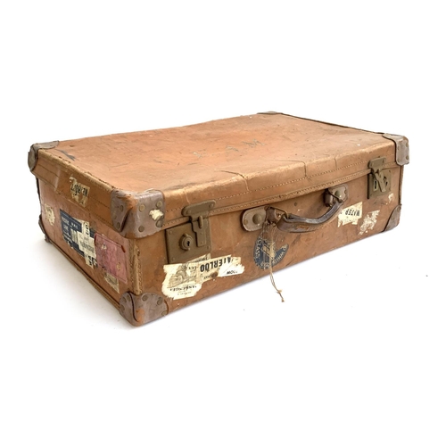 1065 - A vintage suitcase, with leather corner fittings, various travel stickers including Weymouth, Cunard... 