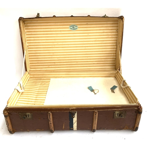 1077 - A canvas and wood banded travel trunk with travel stickers and key, Warranted 3 ply, removable tray