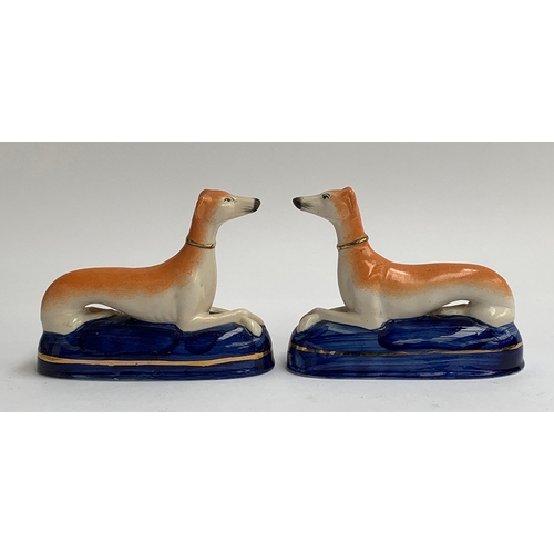 124 - A pair of Staffordshire recumbent greyhound pen holders, each 17cmL