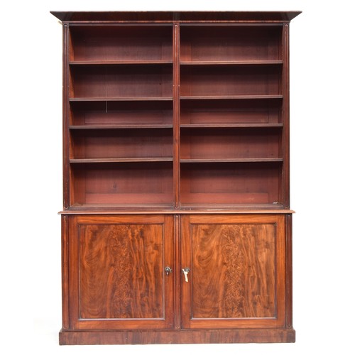 573 - A 19th century mahogany bookshelf, two sections of four shelves, over a base with two cupboard doors... 