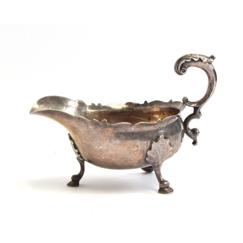 88 - A late Victorian silver sauce boat, wavy edge, acanthus capped scroll handle, raised on leaf capped ... 