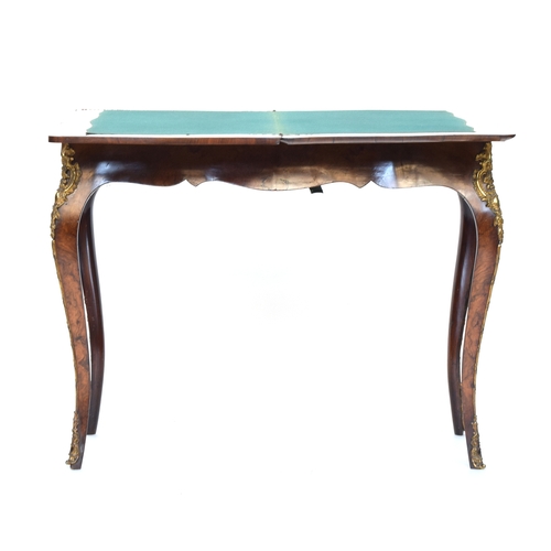 559 - A burr walnut and ormolu mounted swivel top card table, the shaped fold over top lined in green baiz... 