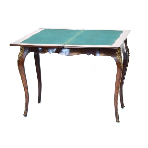 559 - A burr walnut and ormolu mounted swivel top card table, the shaped fold over top lined in green baiz... 