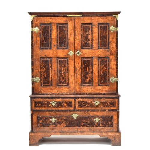 541 - A George I figured oak cabinet on stand, with mulberry panels, the cabinet doors opening to an arran...