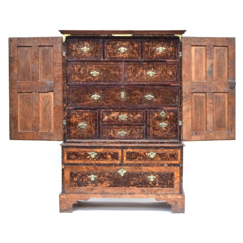541 - A George I figured oak cabinet on stand, with mulberry panels, the cabinet doors opening to an arran... 