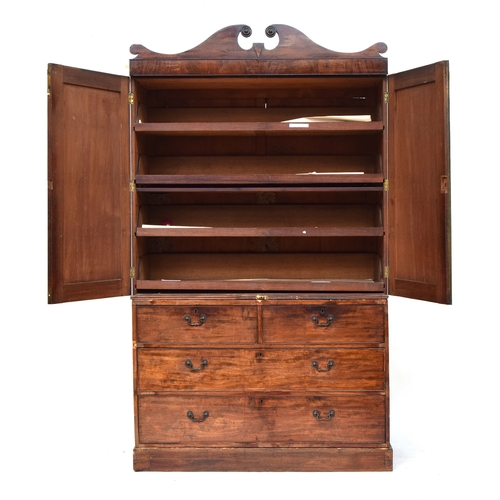 544 - A 19th century mahogany linen press, the broken pediment over two panelled doors opening to slides, ... 