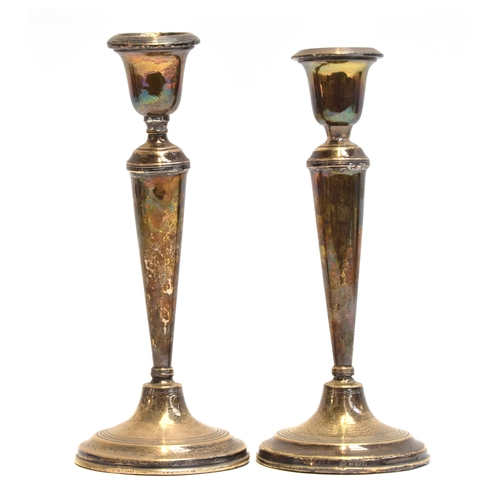 147 - A pair of silver candlesticks by William Hutton & Sons Ltd, Birmingham 1916 (loaded), of tapered cyl... 