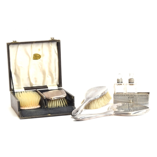 143 - A cased pair of silver clothes brushes by W I Broadway & Co, Birmingham 1963; together with a furthe... 