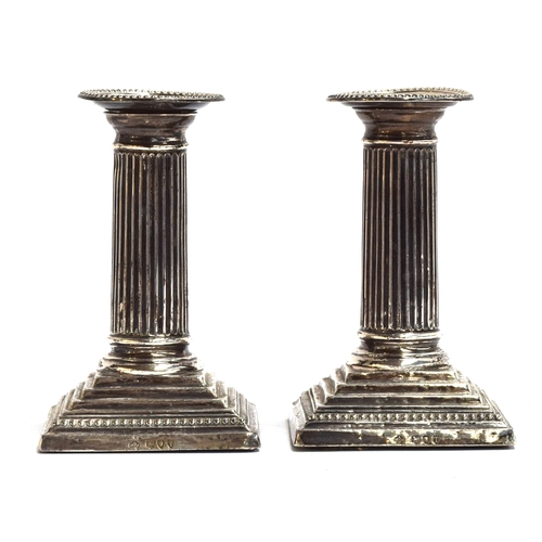 149 - A pair of loaded silver neoclassical candlesticks by William Hutton & Sons Ltd, London 1894, the ree... 