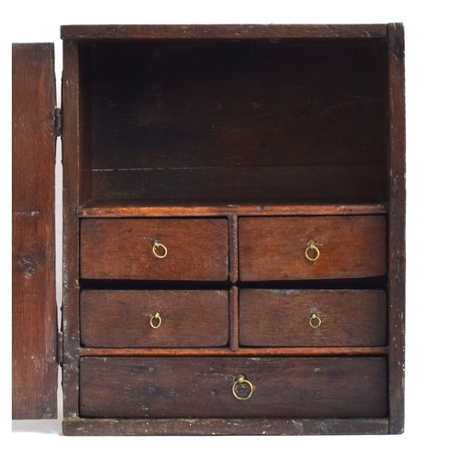 514 - A 17th century oak wall cupboard, single fielded panel door, opening to an arrangement of five shelv... 