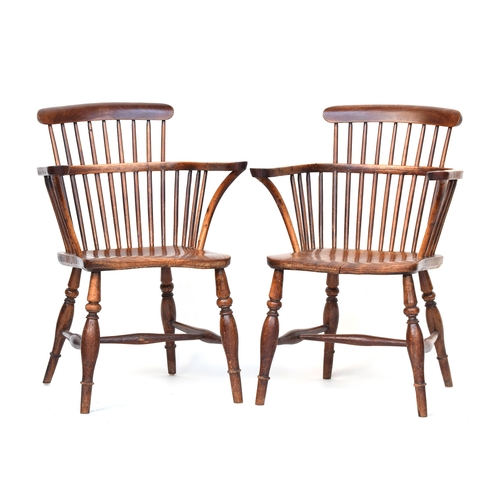 612 - A pair of comb back Windsor chairs, the modified arms with bentwood front supports, on shaped elm se... 