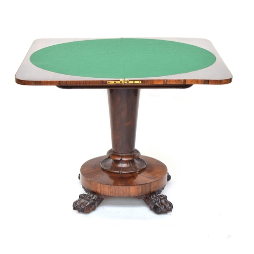 557 - A Victorian rosewood swivel top card table, on tapered turned column, circular base, and four carved... 