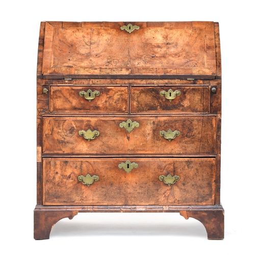 518 - A George I walnut bureau, the cross banded fall front opening to an arrangement of pigeonholes and d... 