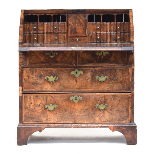 518 - A George I walnut bureau, the cross banded fall front opening to an arrangement of pigeonholes and d... 