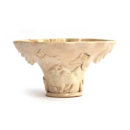 213 - A Chinese blanc de chine libation cup, Fukien province, modelled in the rhinoceros horn form, with a... 