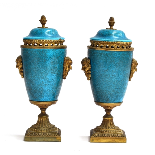 249 - A pair of turquoise enamel and gilt metal lidded urns, with mask decoration and pierced collars, the... 