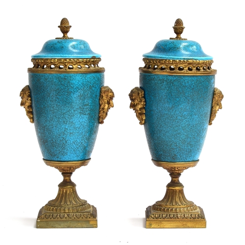 249 - A pair of turquoise enamel and gilt metal lidded urns, with mask decoration and pierced collars, the... 