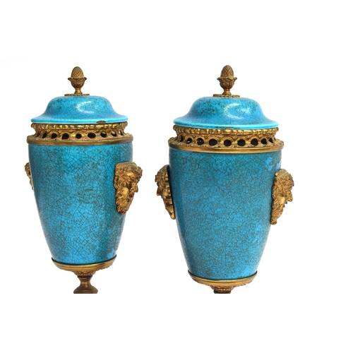 249 - A pair of turquoise enamel and gilt metal lidded urns, with mask decoration and pierced collars, the... 