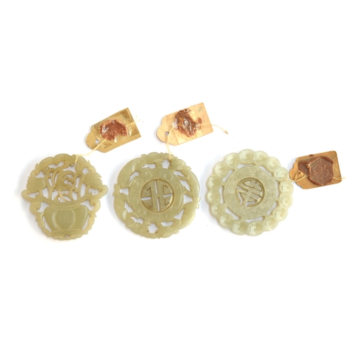 202 - Three Chinese carved and pierced jade medallions, two with reticulated shou medallion to centre, the... 