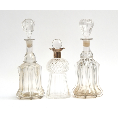 265 - A near pair of decanters, of ribbed bell form, 34cm high, together with one other with silver collar... 