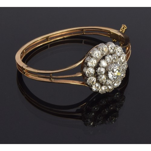 34 - A late 19th century diamond and gold bangle, with a centring of a circular diamond cluster of old-cu... 