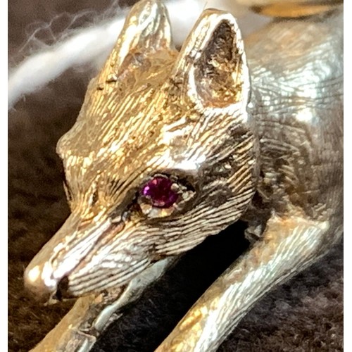 23A - A 9ct gold pendant in the form of a running fox, set with ruby eyes, 4.5cm long approx. 11.2g