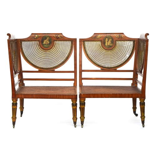 655 - A pair of Edwardian Adam revival satinwood and parcel painted corner armchairs, each with painted cr... 