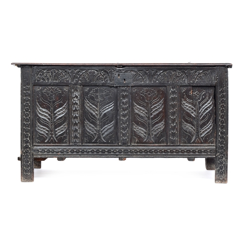 583 - An early 18th century four panel oak coffer, two plank bifold top over a demilune frieze and floral ... 