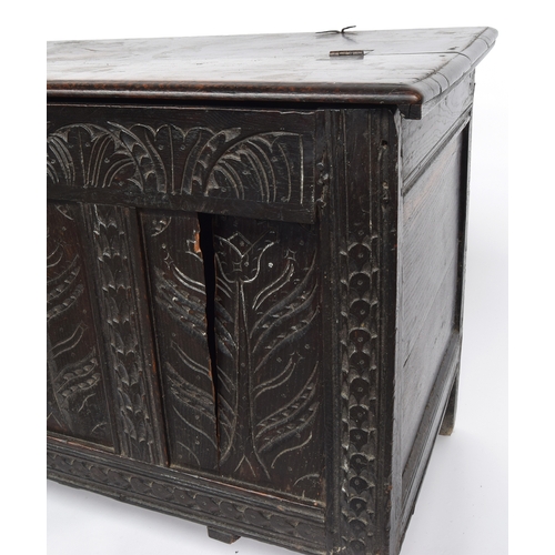 583 - An early 18th century four panel oak coffer, two plank bifold top over a demilune frieze and floral ... 