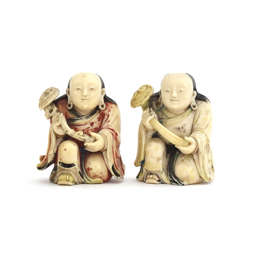 247 - Two Japanese netsukes depicting kneeling priests holding staves, each 6.5cm high