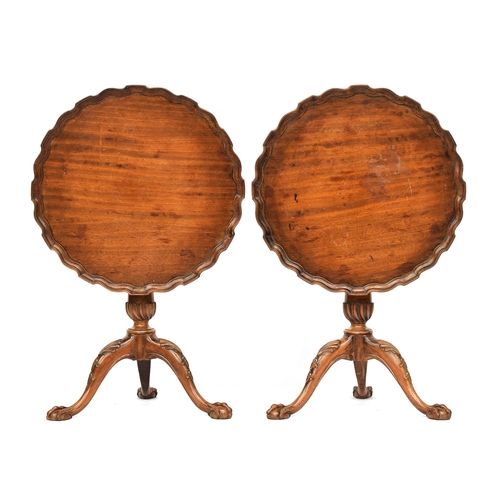 617 - A pair of George II style mahogany tripod tables, each with shaped pie crust tilt top on a gun barre... 